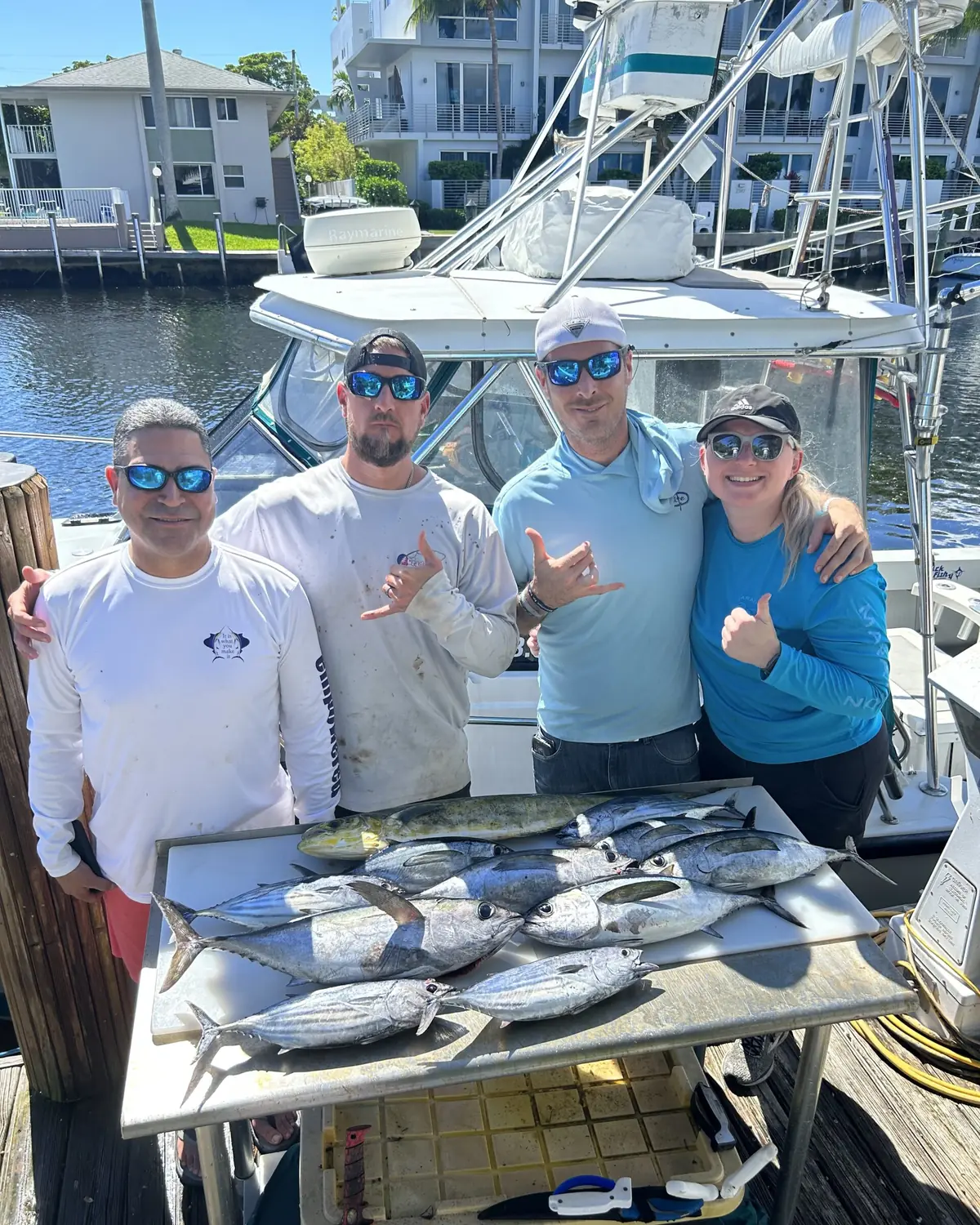 Four anglers behind a cleaning table full of fish at the dock